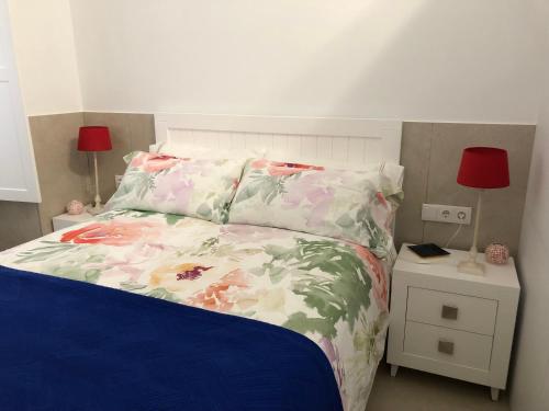 加的斯Jano PuertaTierra的一间卧室配有一张带花卉床罩的床