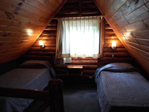 普埃洛湖CABAÑAS LOS PATOS的小木屋内一间卧室,配有两张床