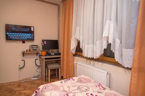 达鲁瓦尔Rooms Vlado的一间卧室配有一张床、一张书桌和一个窗户。
