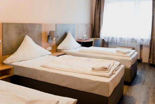美因河畔法兰克福皇家酒店的酒店客房设有三张床和窗户。