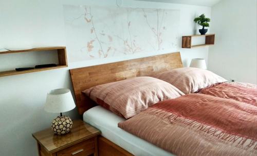 巴特塔茨曼斯多夫Baum Apartments的一间卧室配有一张床和一张带台灯的桌子