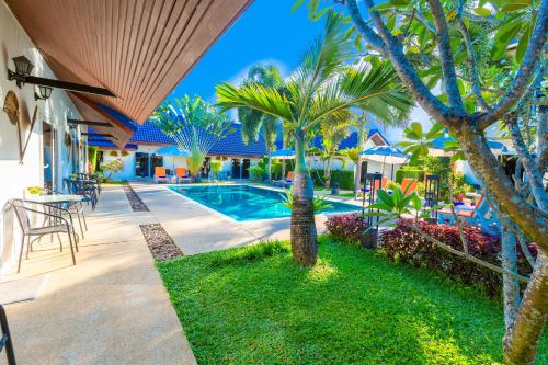 奈扬海滩Phuket Airport Hotel - SHA Extra Plus的一座别墅,设有游泳池和棕榈树