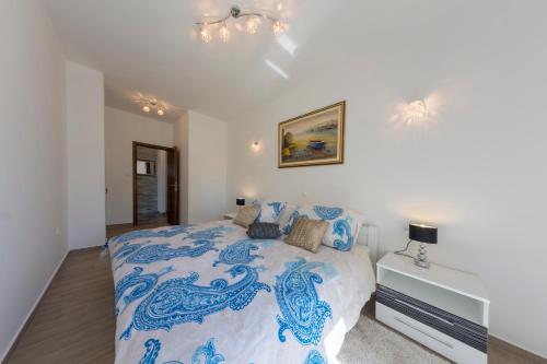 斯克拉丁Villa Scolopax rusticola Skradin with heated pool的卧室配有蓝色和白色的床和枕头