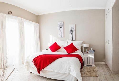 科尔切斯特Settle Inn Self Catering Accommodation的一间卧室配有一张带红色枕头的大床