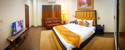 拉合尔Hayyat Luxury Apartments的酒店客房设有一张大床和一台电视。
