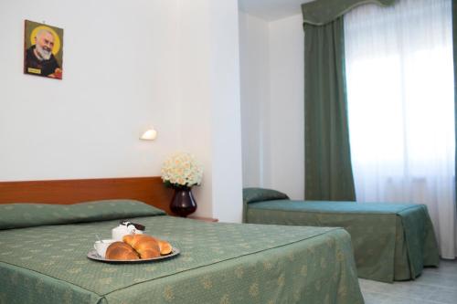 圣乔瓦尼·罗通多阿尔伯格侯爵别墅酒店的酒店客房,设有两张床,配上一盘面包