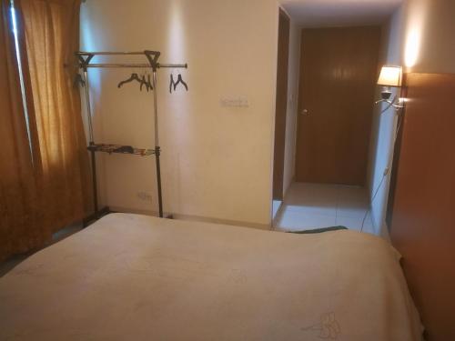 达卡Rajanigandha Family Suites的一间卧室配有一张床,另一间卧室配有衣柜