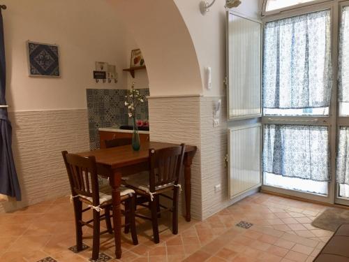 卡尔塔吉罗Trio D'Archi - La Maison de Cocò的厨房配有木桌、椅子和窗户。
