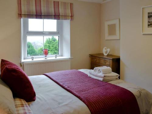 HawesMiddlegate Cottage的一间卧室配有一张带窗户的床和毛巾