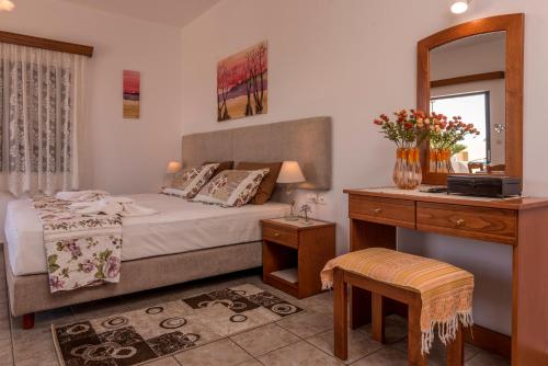 帕琉乔拉Roula Apartments的一间卧室配有一张床、一张书桌和一面镜子