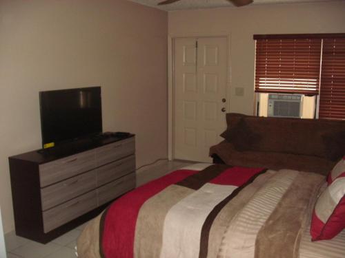 劳德代尔堡Newly Furnished Large, Clean, Quiet Private Unit的一间卧室配有一张床和一台平面电视
