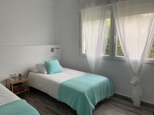 托雷德本纳贾尔邦El Rincón de Cristina的一间白色卧室,配有床和2个窗户