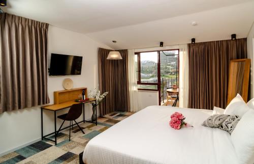 耶路撒冷Biazi Hotel的酒店客房,配有一张白色大床,上面有鲜花