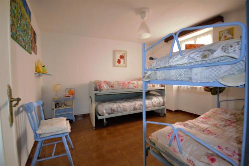 OrtonovoCasa Morellini的带两张双层床和椅子的房间
