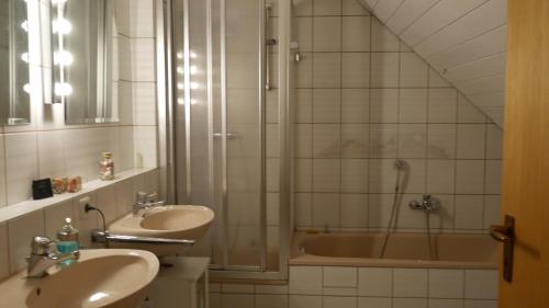 纽伦堡Ruhiges Zimmer Nähe Nürnberg Messe mit Wallbox的带淋浴、两个盥洗盆和浴缸的浴室