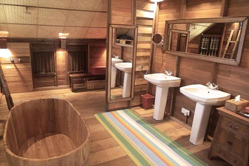 珍南海滩Bon Ton Antique Wooden Villas的大型浴室设有两个盥洗盆和浴缸。