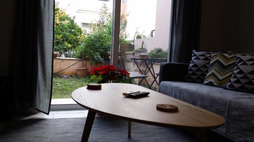 雅典Athenian apartment with garden, near metro station Chalandri Nu 3的客厅,窗户前配有茶几