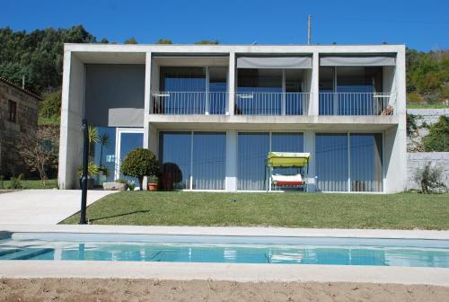 LongosQuinta Pedras De Baixo的一座房子前面设有游泳池
