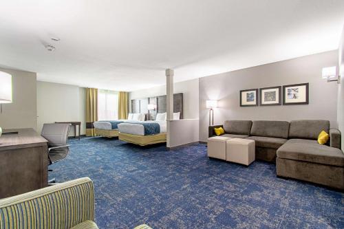 亨博尔Comfort Suites Humble Houston IAH的酒店客房设有一张沙发和一张床