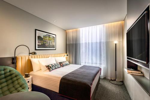 悉尼Veriu Green Square的配有一张床和一台平面电视的酒店客房