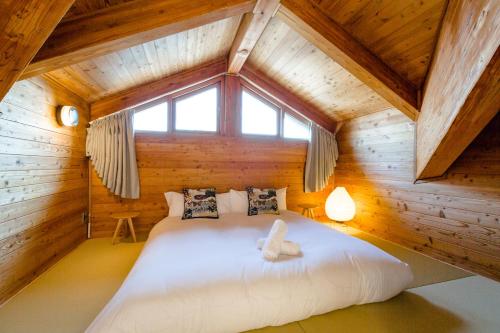 白马村Wadano Gateway Suites & Apartments的小木屋内的卧室配有一张大床