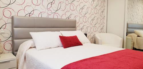 格罗韦BALEA 62的卧室配有白色的床和红色枕头