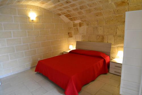 莫诺波利Dimora Arco Antico的一间石墙卧室,配有红色的床