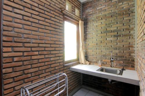 卡里乌昂Disaster Oasis的砖墙浴室设有水槽和窗户