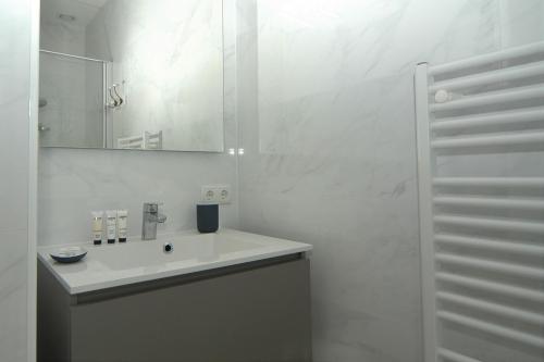 卡德赞德La Promenade Le Normandy 54-201的白色的浴室设有水槽和镜子