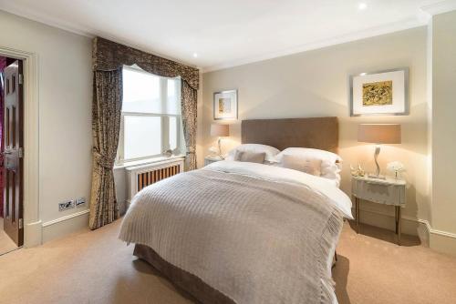 伦敦Grand Ambassadorial Duplex Apartment Hyde Park的一间卧室设有一张大床和一个窗户。