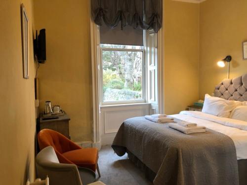 爱丁堡Allison House 16的一间卧室设有一张床、一个窗口和一把椅子
