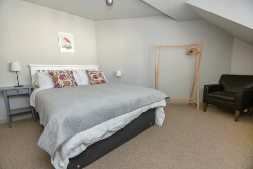 布莱顿霍夫Arundel Mews - Parking - by Brighton Holiday Lets的一间卧室配有一张大床和一把椅子