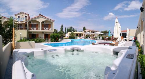 斯卡拉卡伦尼斯艾美提度假酒店的房屋旁的带热水浴池的游泳池