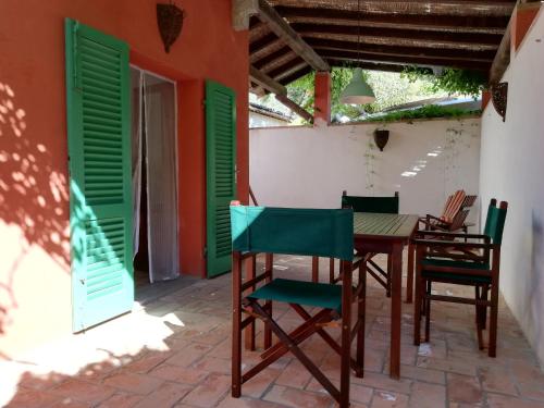 普罗基奥Rosa dei Venti的庭院配有桌椅和绿色百叶窗