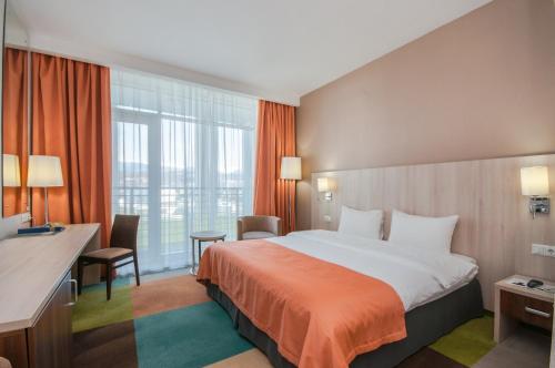 阿德勒Omega Sirius的酒店客房设有一张床和一个大窗户