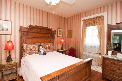 五月岬郡Thomas Webster House的一间卧室,卧室里配有一张床,狗坐在床上