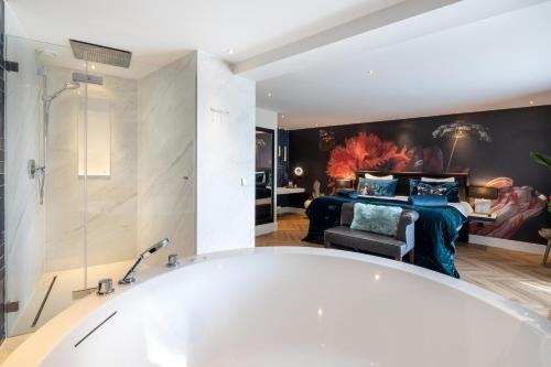 莱顿凡德瓦克酒店的带浴缸的浴室和卧室