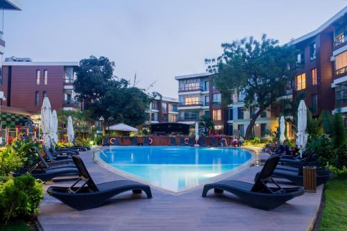 阿克拉Accra Fine Suites - The Pearl In City的一个带躺椅和椅子的游泳池