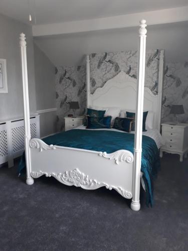鲍内斯温德米尔纽霍班克旅馆的卧室配有白色的天蓬床和蓝色的床单