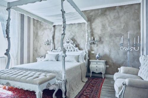 明乔河畔蓬蒂La Zarabba Boutique Hotel的卧室配有白色的天蓬床和沙发。