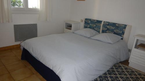 科利尤尔Les mimosas的卧室配有白色的床和窗户。