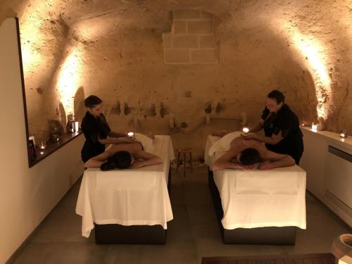 格拉维纳普利亚Le Fornaci Imperial Lodge & Spa的两人坐在带蜡烛的房间的床上