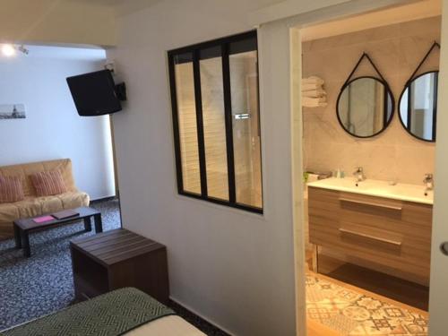 鲁西隆地区卡内Le Galion Hotel et Restaurant Canet Plage - Logis的客房设有带水槽和镜子的浴室