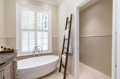 开普敦Dalton House的带窗户的浴室内的白色浴缸