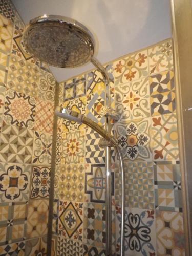 Avilly-Saint-Léonard勒布拉姆住宿加早餐旅馆的浴室的墙壁上设有瓷砖,浴室内则设有淋浴。