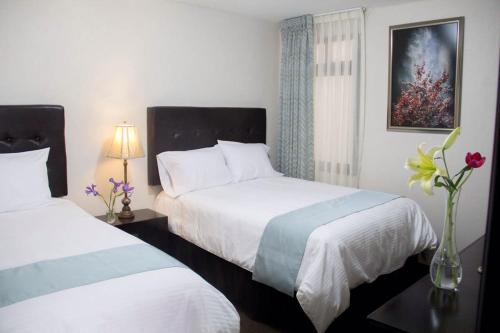 奇格纳瓦潘Hotel Nube Nueve的酒店客房带两张床和花瓶