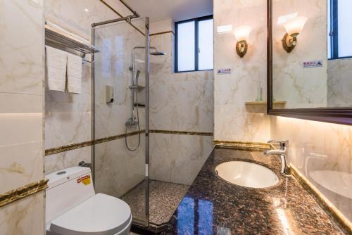 海口海南京山酒店的浴室配有卫生间、盥洗盆和淋浴。