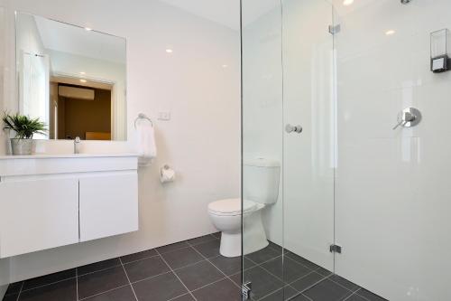 悉尼Kingsgrove Hotel的一间带卫生间和玻璃淋浴间的浴室
