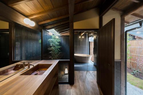京都Nazuna Kyoto Gosho的浴室配有大水槽和浴缸。