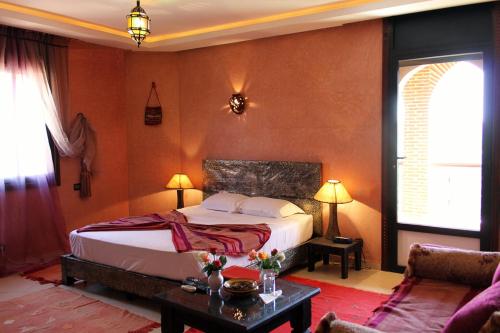 马拉喀什达尔欧拉纳宫住宿加早餐旅馆的一间卧室配有一张床、一张桌子和一张沙发